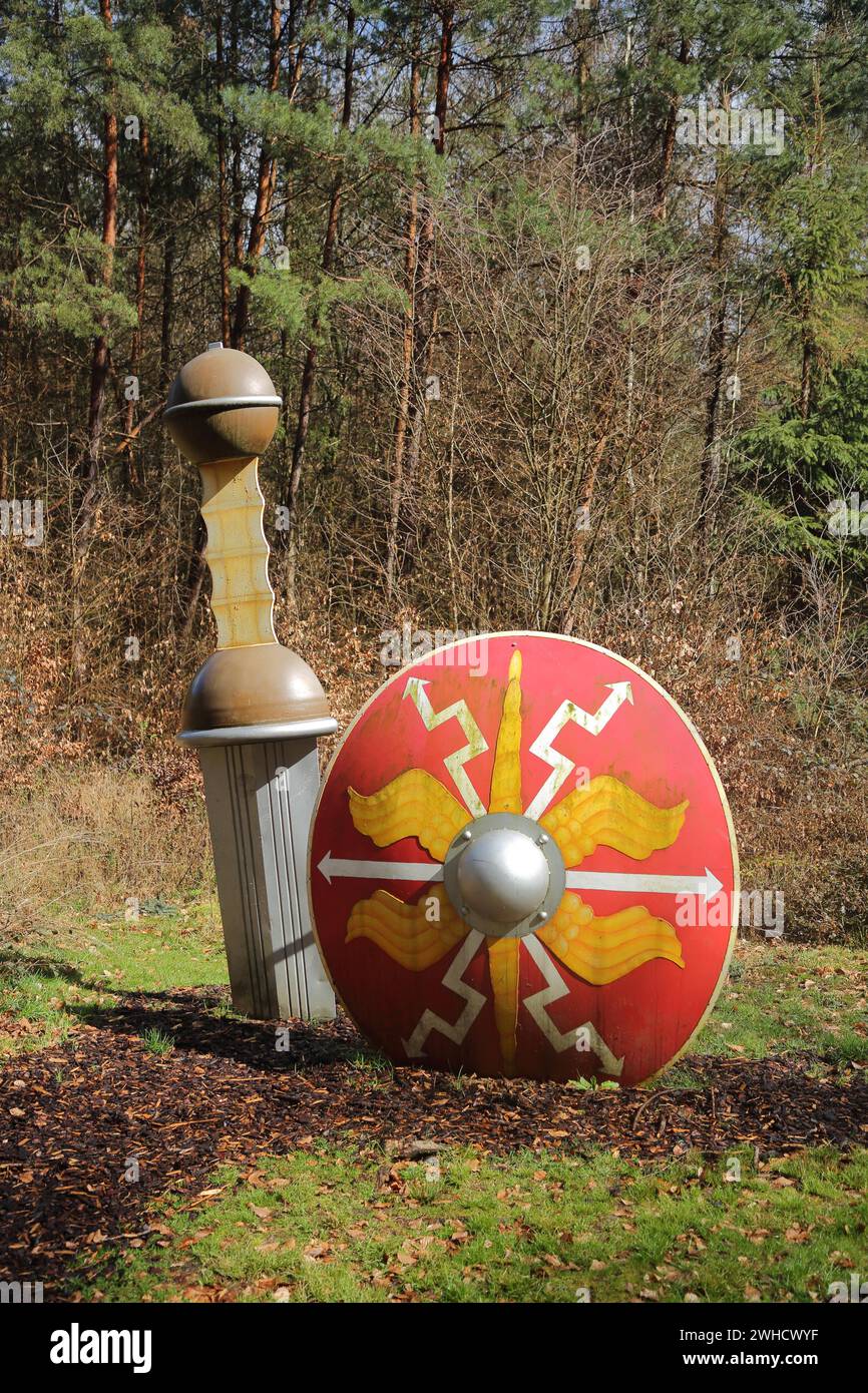 Sculpture épée romaine et bouclier par Jox Reuss 2004, romain, arme poignarde, arme, coincé dans le sol, forêt, Limesrundweg, Limeshain, Wetterau Banque D'Images