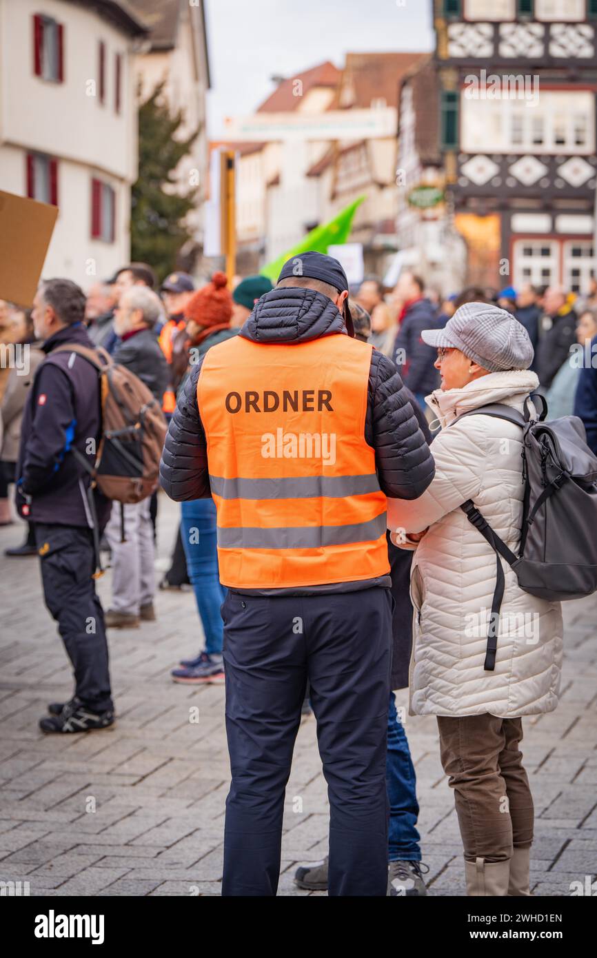 Deux personnes parlant lors d'une manifestation, une en gilet de police, derrière eux une rue de la ville, contre Right Demo, Nagold, Forêt Noire, Allemagne Banque D'Images