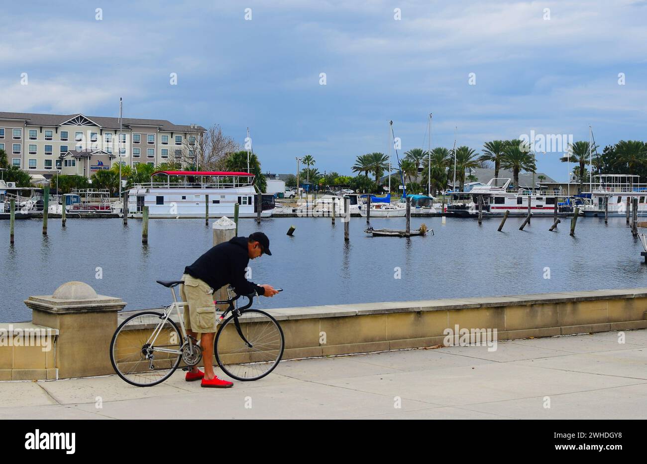 Homme sur le vélo à la marina regardant le téléphone, lac Monroe, Sanford, Floride Banque D'Images