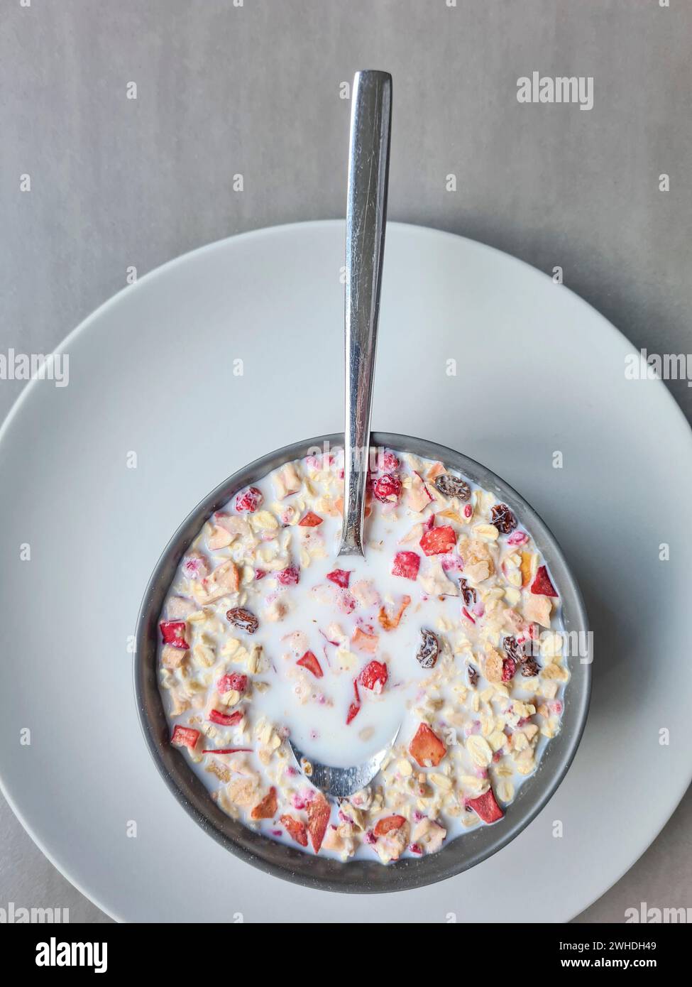 Muesli avec du lait dans un bol pour le petit déjeuner, muesli aux fruits avec des grains et des fruits, cuillère Banque D'Images