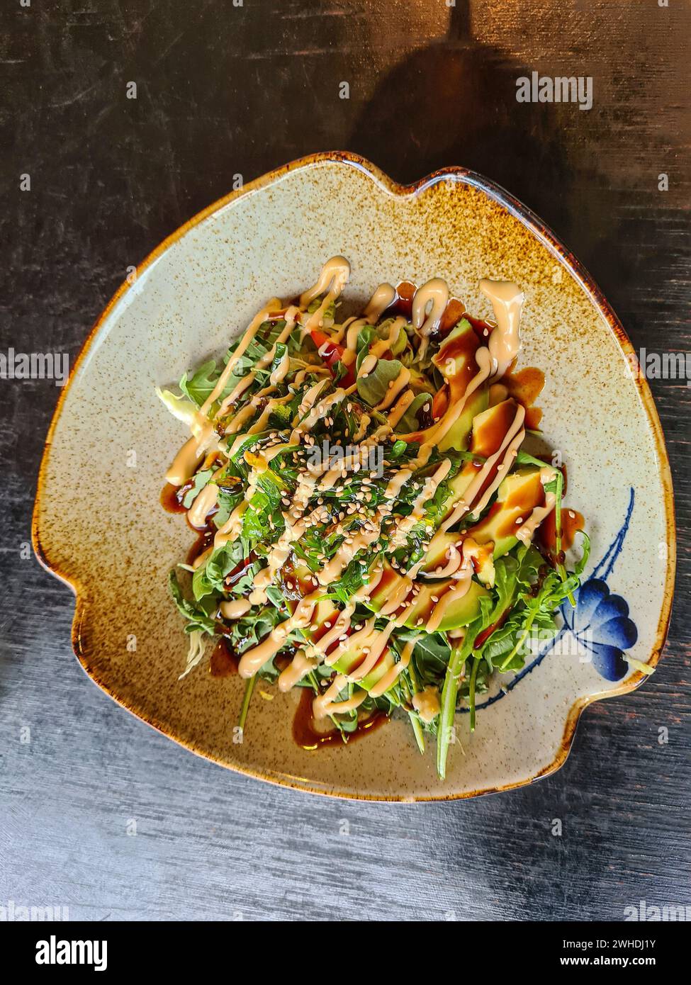 Salade d'avocats avec algues, légumes, graines de sésame, sauce unagi au restaurant Banque D'Images