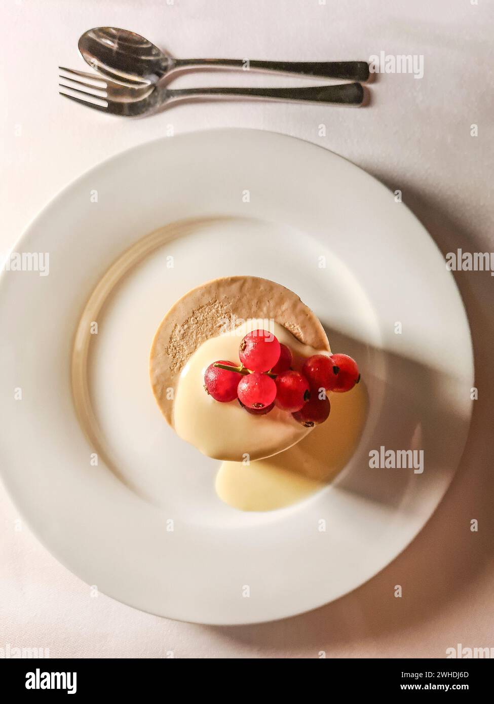 Petite tartelette à saveur caramel et sauce vanille garnie de groseilles fraîches Banque D'Images