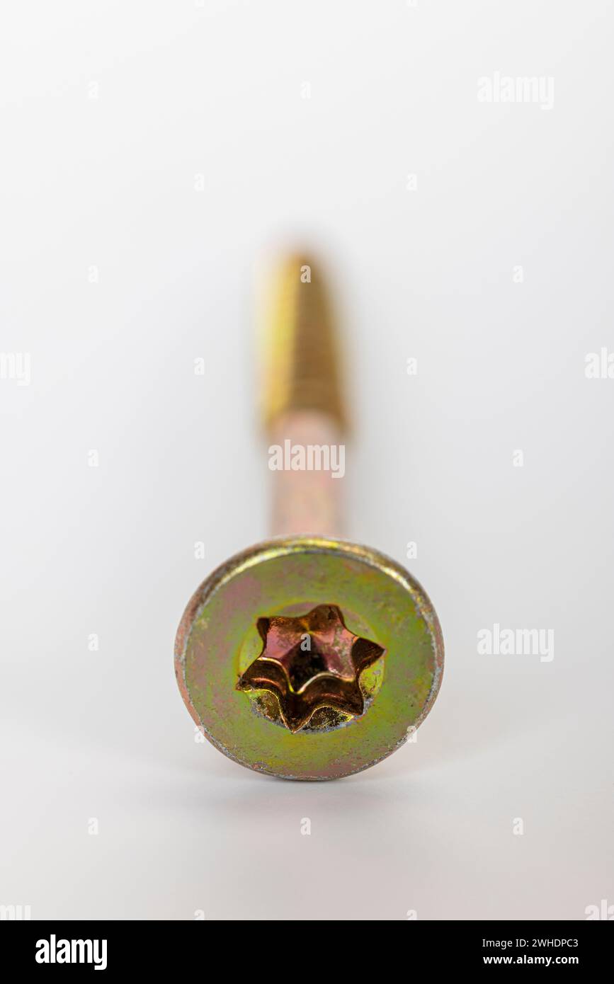 Vis Torx simple pour panneaux de particules à tête fraisée, galvanisée jaune, floue, fond blanc, Banque D'Images