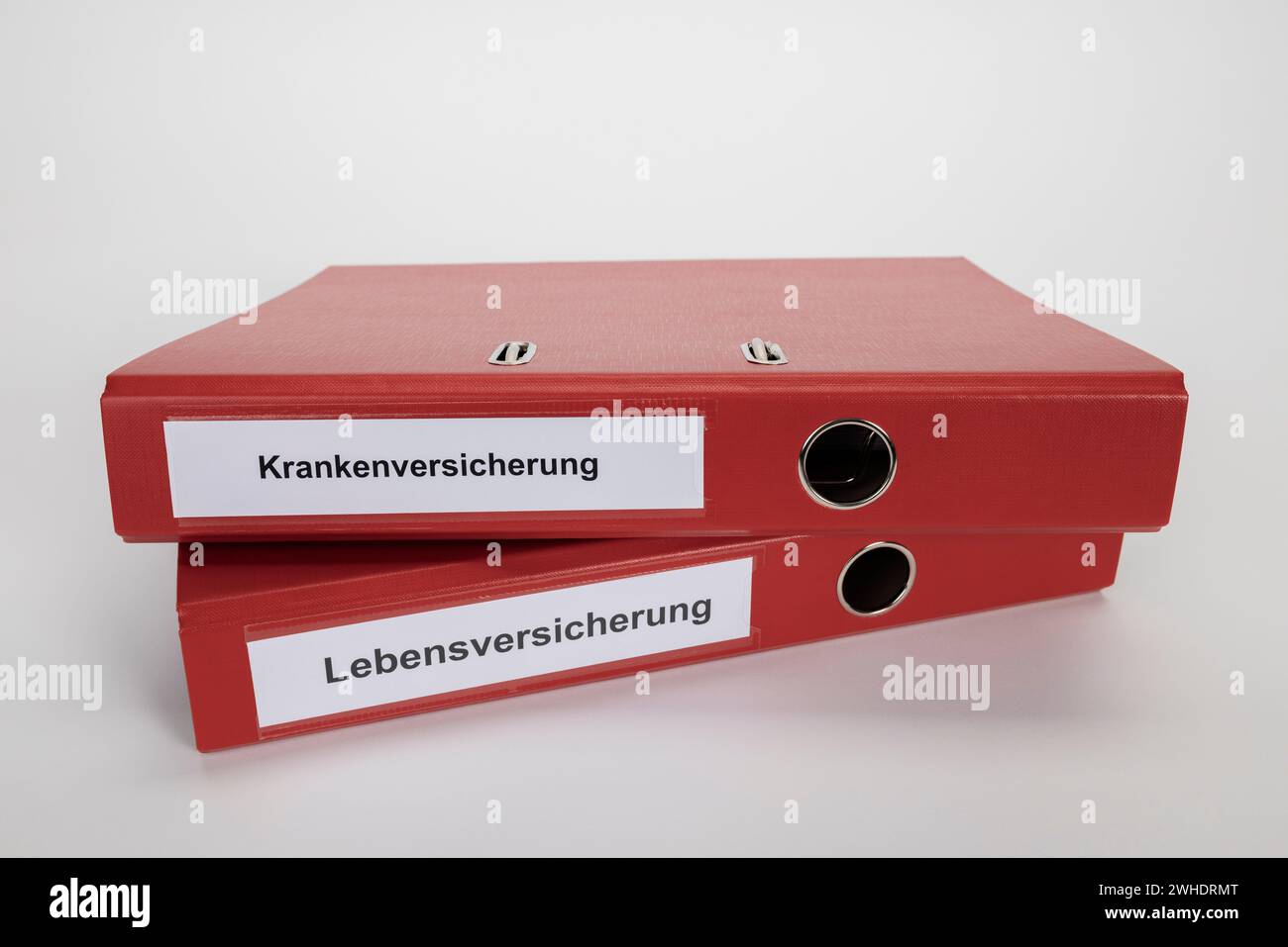 Dossiers rouges étiquetés assurance maladie, assurance vie, image symbolique, provision vieillesse, fond blanc, Banque D'Images