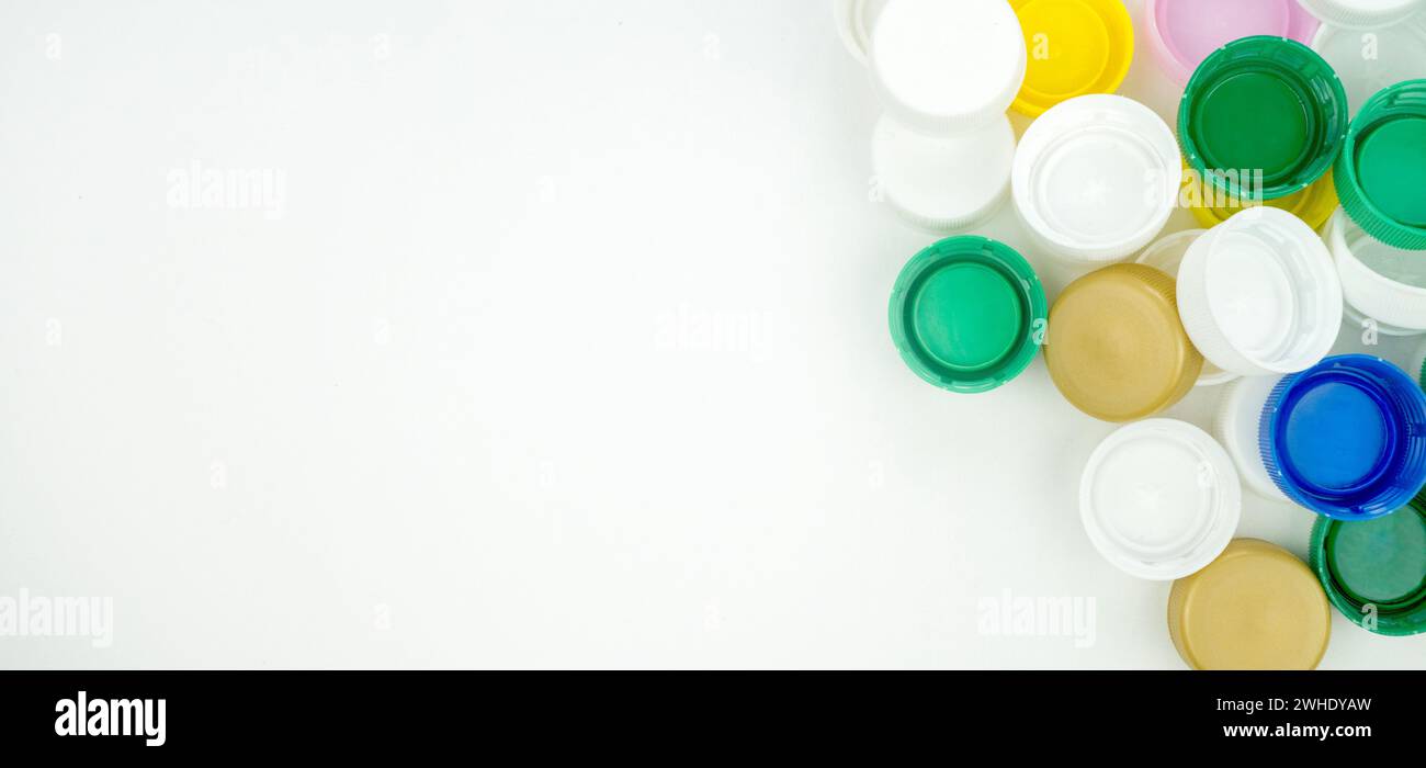 Gros plan d'une pile de bouchons de bouteilles en plastique de différentes couleurs. Concept de pollution plastique, de recyclage et de durabilité. Banque D'Images