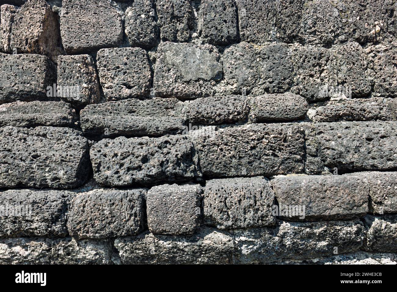 La texture d'un vieux mur de briques en pierre altérée met en valeur son aspect vieilli et usé Banque D'Images