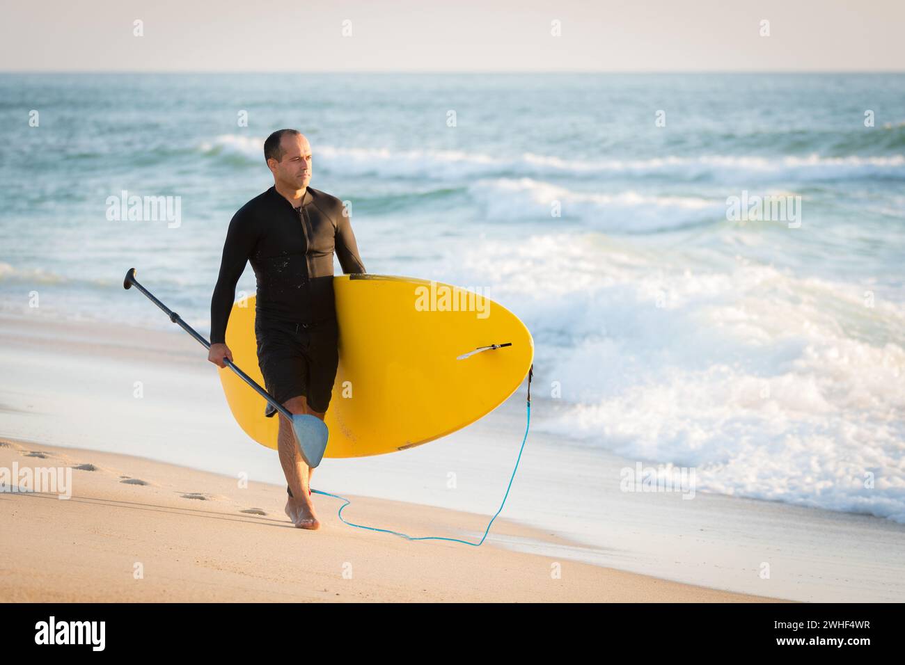 Homme avec sa planche à pagaie Banque D'Images