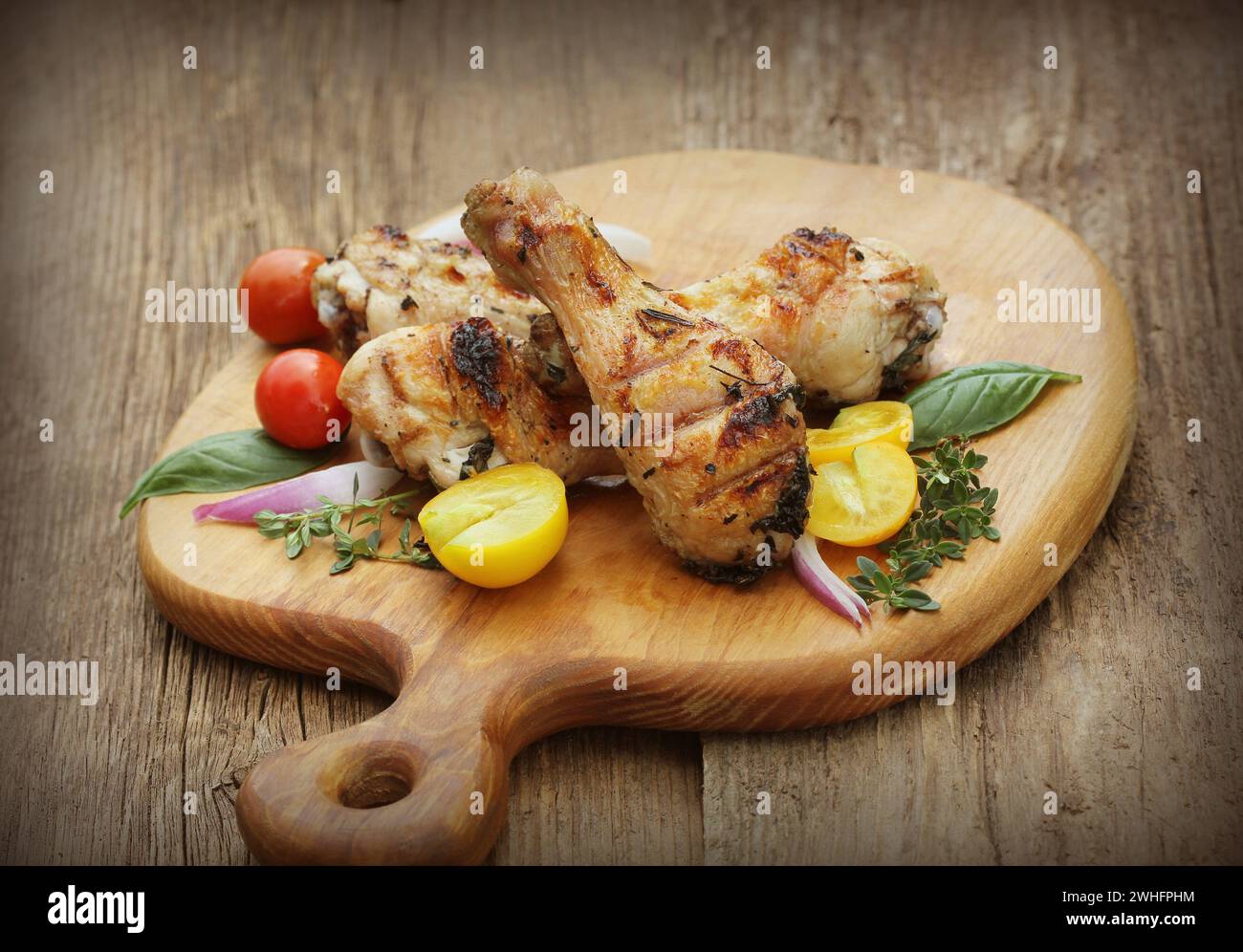 Cuisses de poulet grillées au romarin servi sur une planche à découper le dîner historique Banque D'Images
