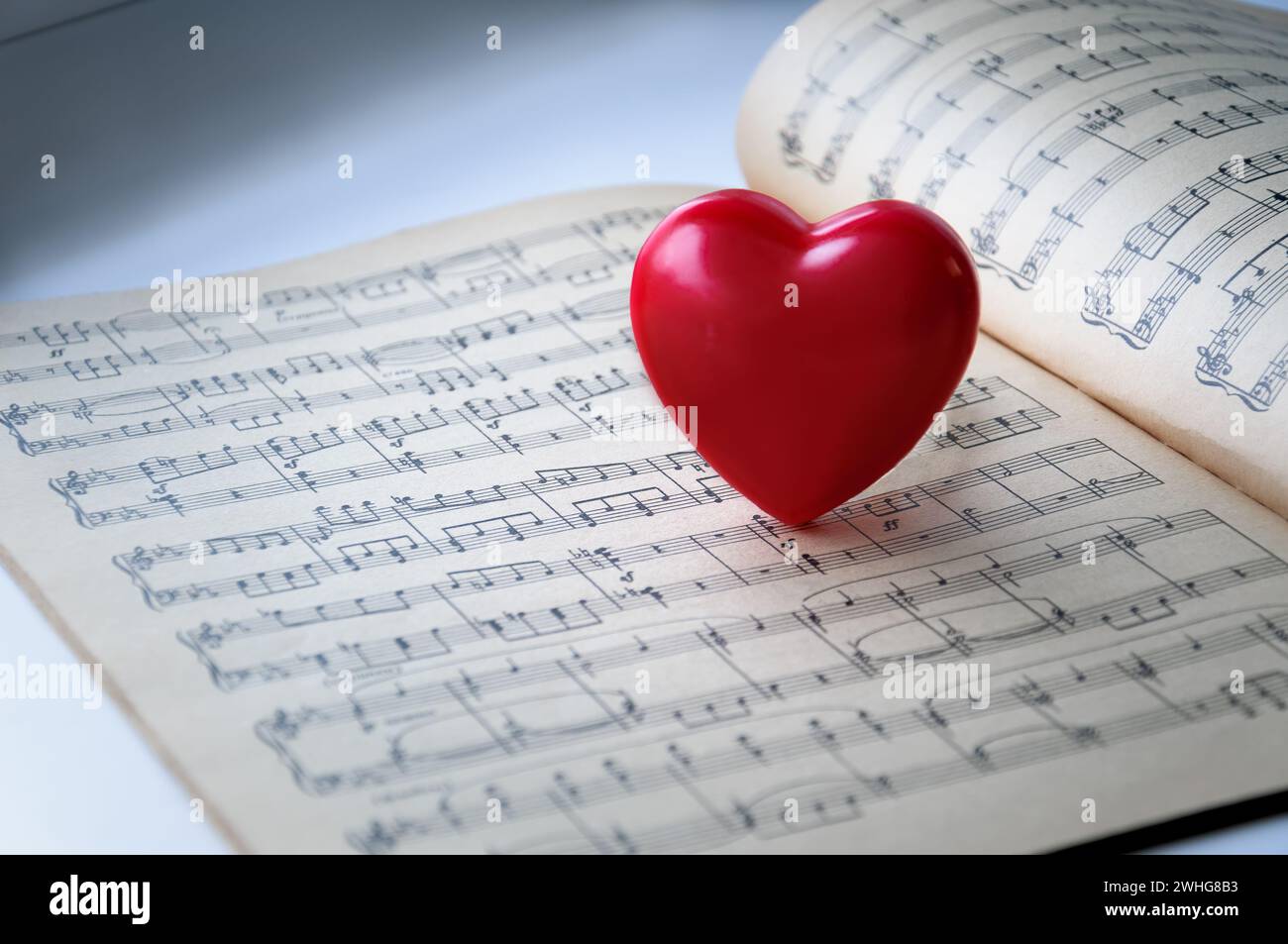 Cœur rouge sur fond de notes. Le cœur rouge est sur les notes. Banque D'Images