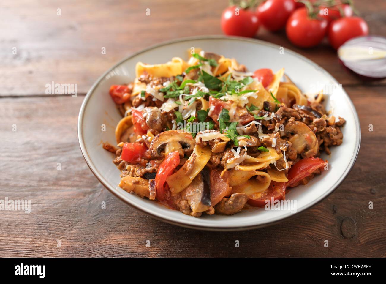 Tagliatelle avec sauce à base de viande hachée, tomates et légumes à la bolognaise, avec parmesan et persil sur une assiette et un Banque D'Images