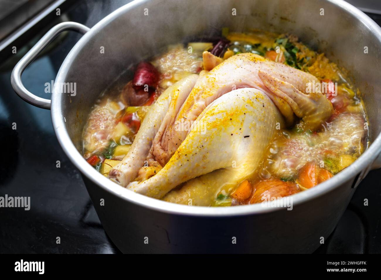 Soupe de poulet avec des légumes et des épices est bouillante dans une casserole, la cuisson d'un bouillon sain, remède maison contre le rhume et la grippe, sélectionné Banque D'Images