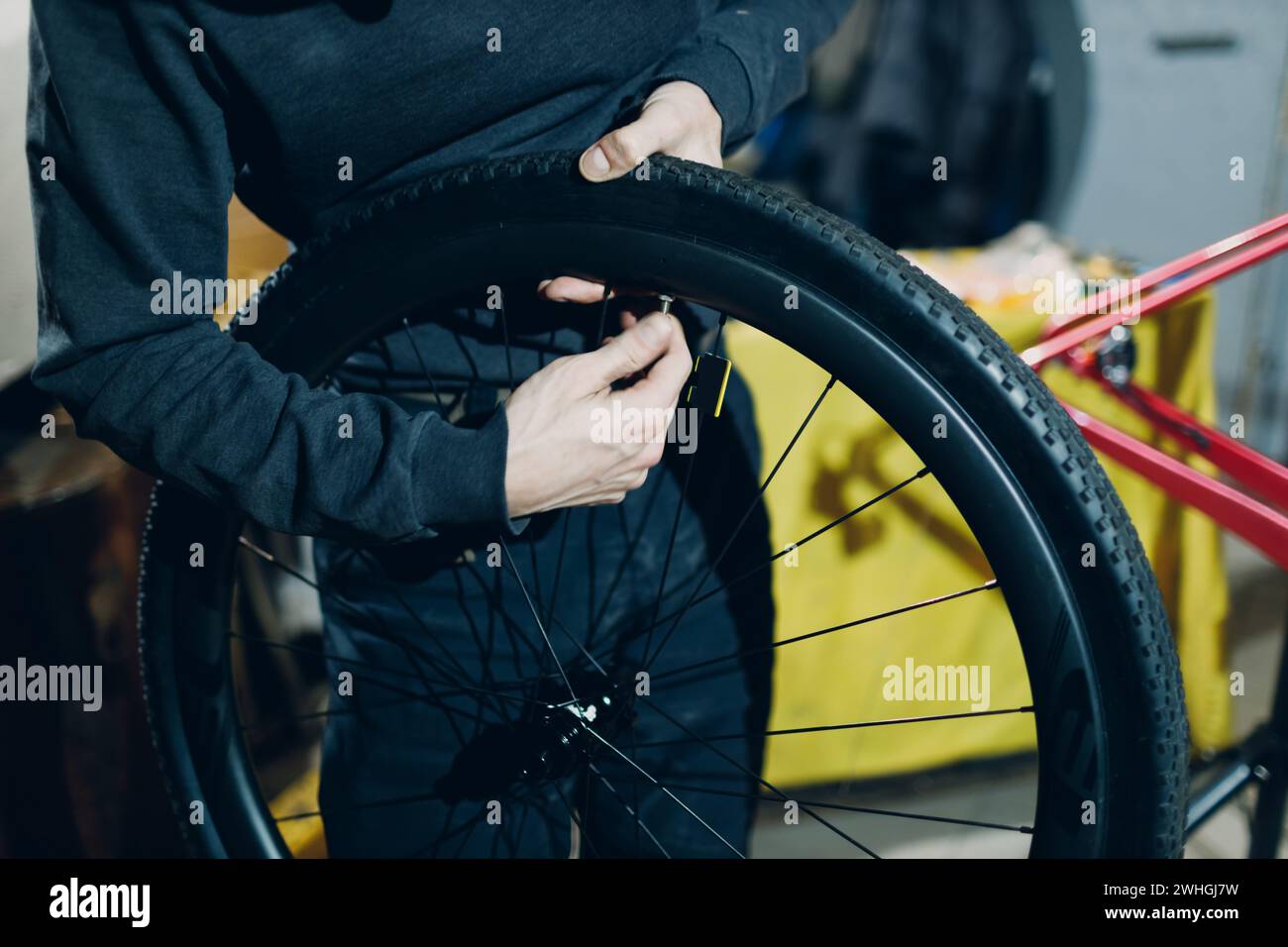 Mécanicien réparateur assemblant le vélo personnalisé jante de mamelon de roue en atelier. Banque D'Images