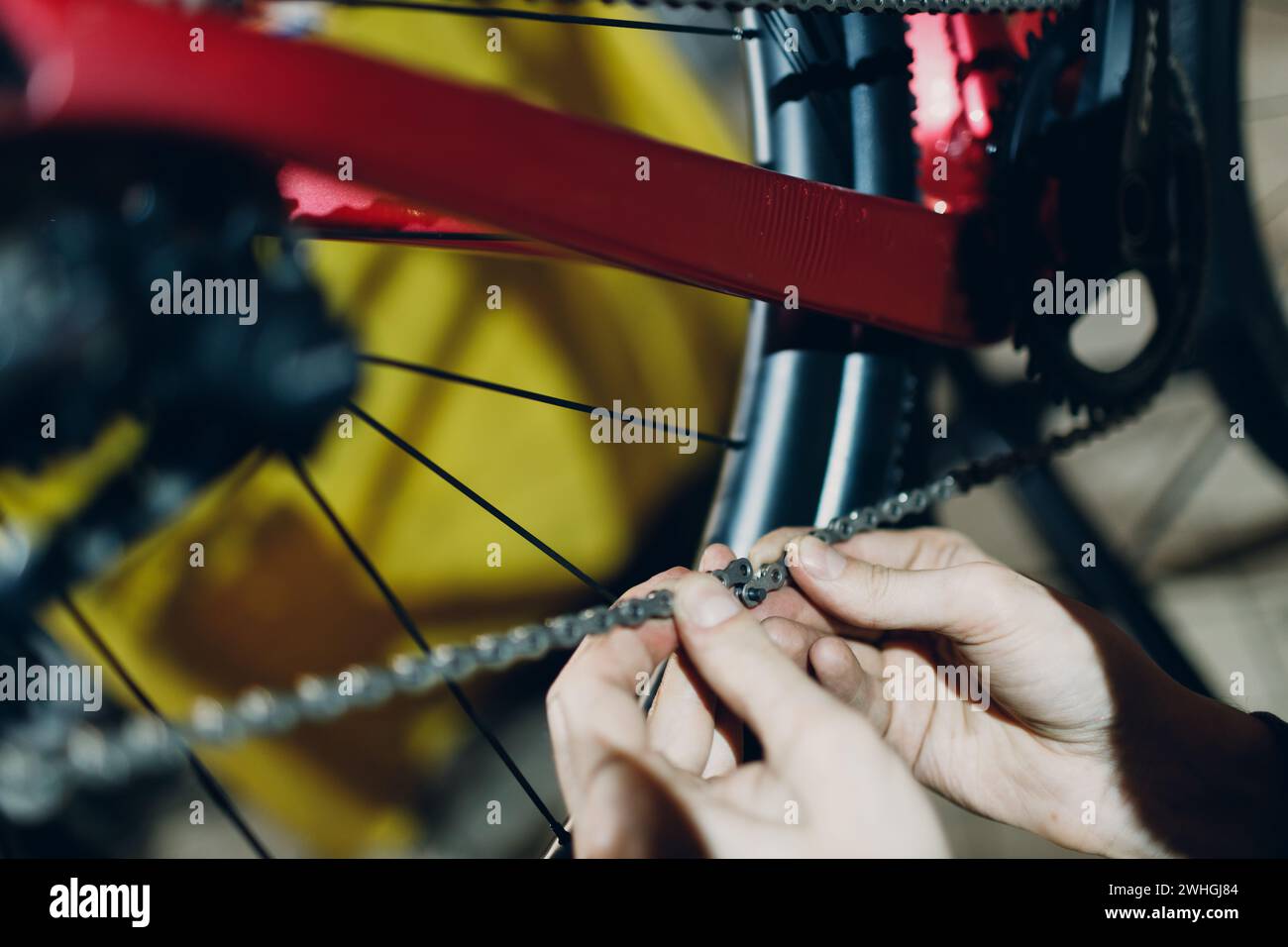 Mécanicien réparateur assemblant un vélo personnalisé installant un maillon de rivet de chaîne en gros plan. Banque D'Images