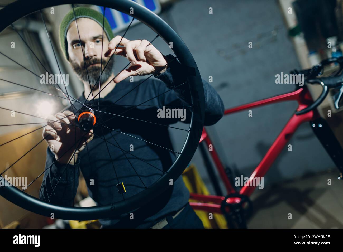 Mécanicien réparateur assemblant roue vélo sur mesure en atelier. Banque D'Images
