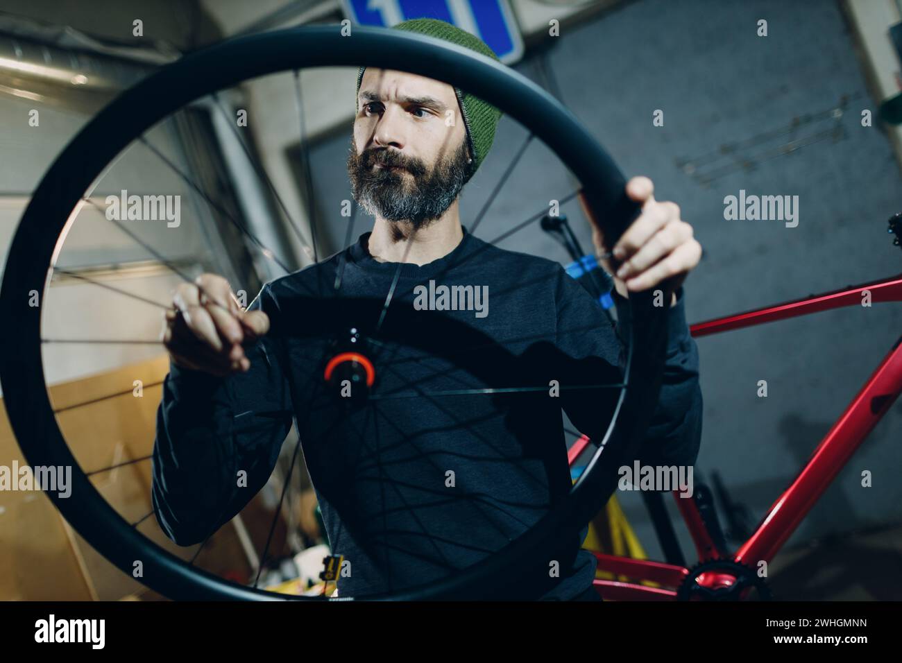 Mécanicien réparateur assemblant roue vélo sur mesure en atelier. Banque D'Images