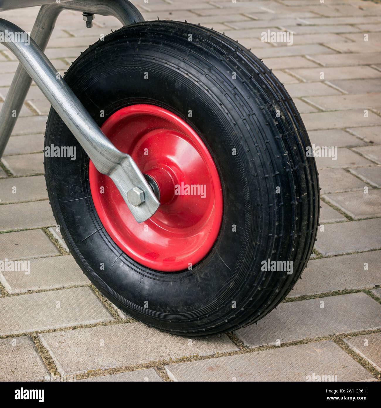 Détail de brouette de jardin. Roue avec un disque rouge Banque D'Images