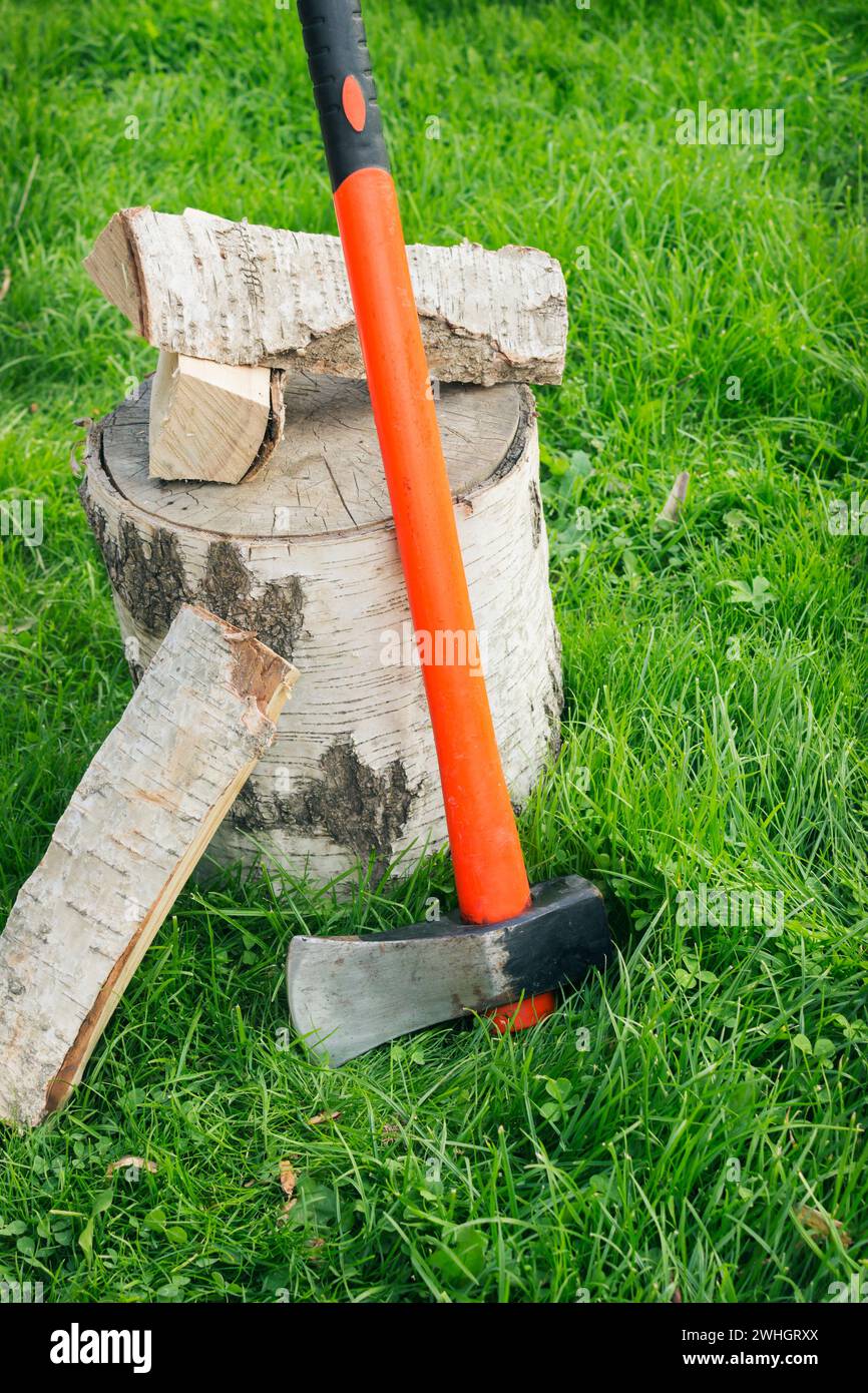 Fendre la hache à un talon et du bois de chauffage sur l'herbe Banque D'Images