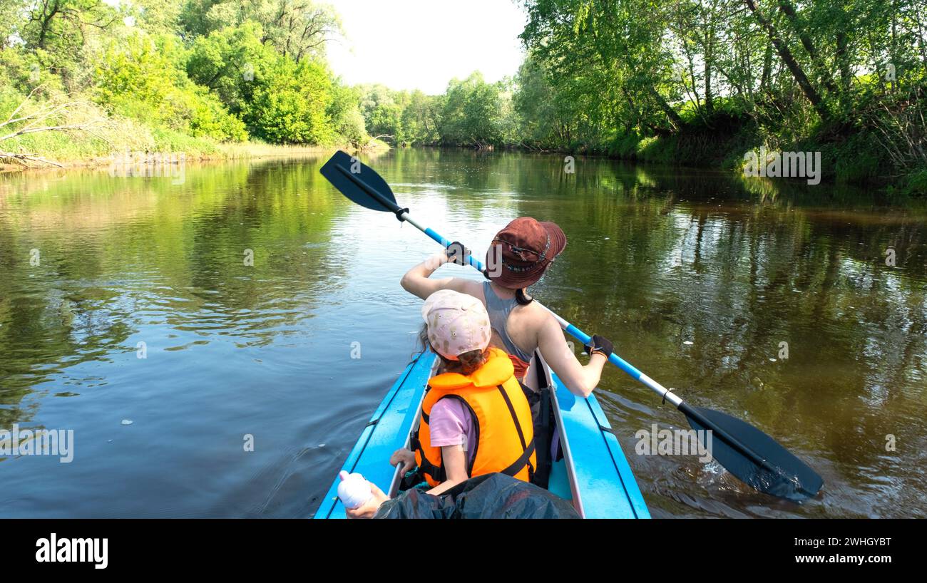 Excursion en kayak en famille. Maman et fille ramant un bateau sur la rivière, une randonnée aquatique, une aventure estivale. Touri écologique et extrême Banque D'Images