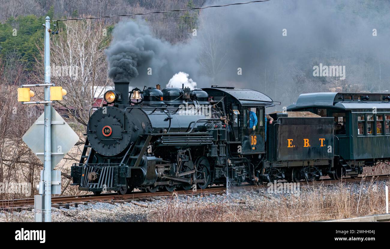 Vue d'un train de passagers à vapeur à voie étroite restauré soufflant de la fumée et voyageant à travers des terres agricoles Banque D'Images