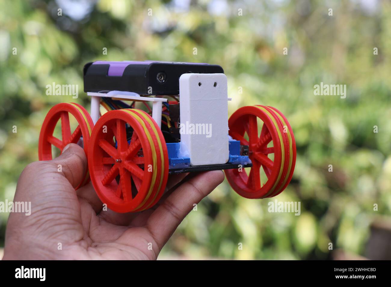 Robot STEM ou également appelé voiture robotique qui est construit pour l'apprentissage de l'électronique et de la programmation tenu dans la main. Modèle de travail d'un véhicule robotique Banque D'Images