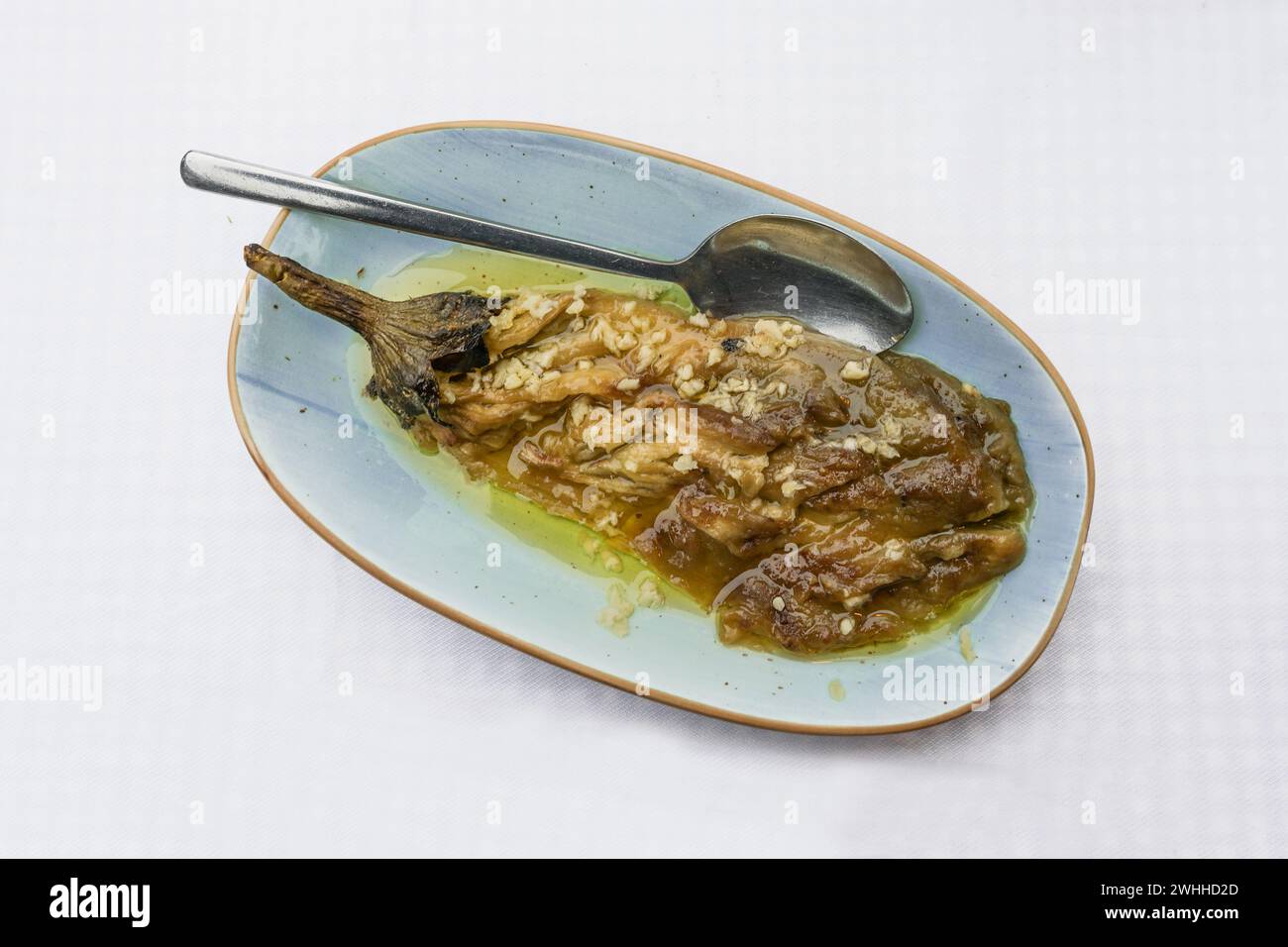 Aubergine cuite et pelée à l'huile d'olive et à l'ail sur une assiette bleue, plat méditerranéen, vue en angle d'en haut, espace copie, Banque D'Images