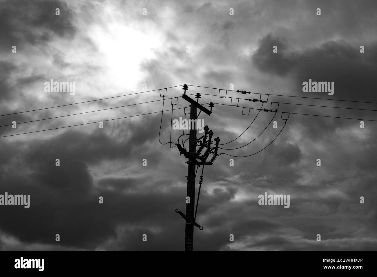 Câble d'alimentation aérien, en noir et blanc, isolé contre le ciel couvert UK Banque D'Images