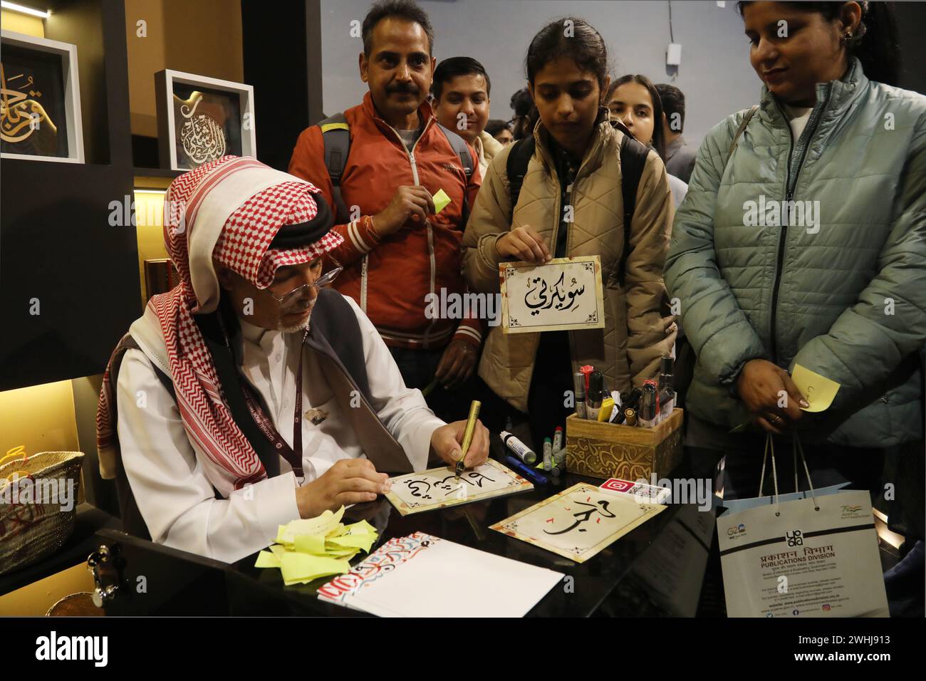 New Delhi, Inde. 10 février 2024. Un artiste calligraphique de l'Arabie Saoudite écrit le nom des visiteurs à des stands le premier jour de la Foire mondiale du livre 2024 avec le thème «L'INDE MULTILINGUE» Une tradition vivante, à Pragati Maidan. Le Royaume d'Arabie saoudite est le pays invité de la foire In Book 2024. La foire se poursuivra jusqu'au 18 février et accueillera plus de 200 stands de livres en plusieurs langues. Crédit : SOPA images Limited/Alamy Live News Banque D'Images