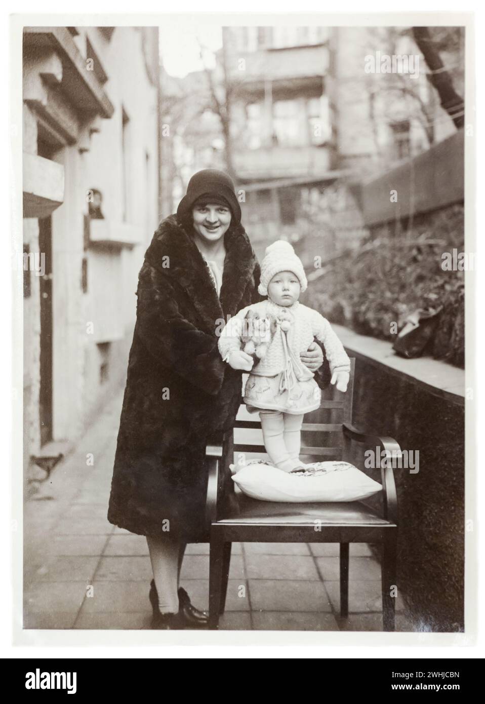 Circa 1920, Allemagne. Portrait de jeune mère avec son enfant, à l'extérieur. Femme avec manteau de fourrure, vêtements Banque D'Images