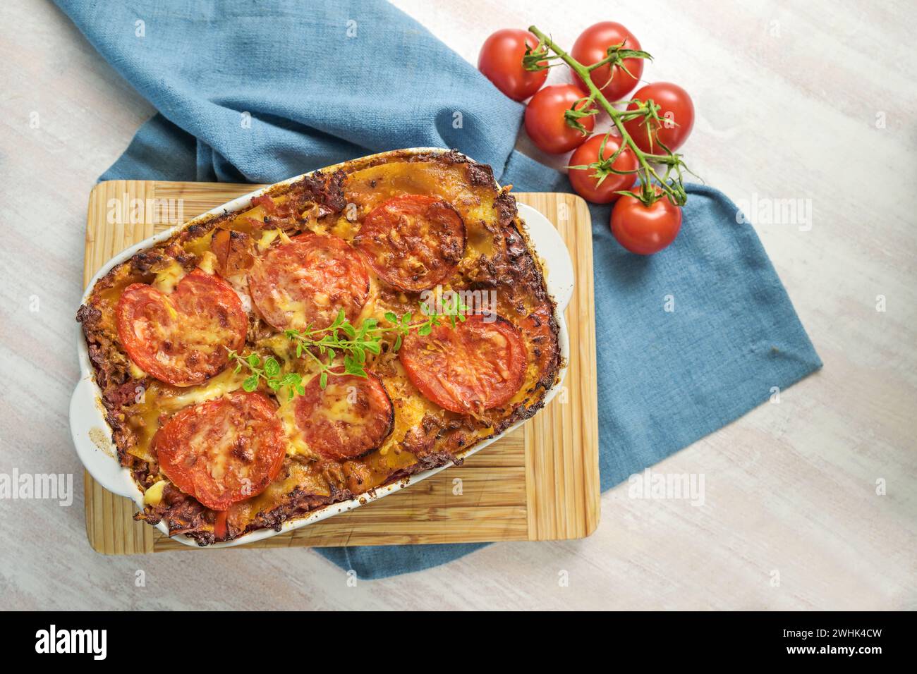 Lasagne, casserole avec des couches de pâtes, sauce bœuf bolognaise, légumes et tomates, nappées de fromage fondu sur un Kitc en bois Banque D'Images