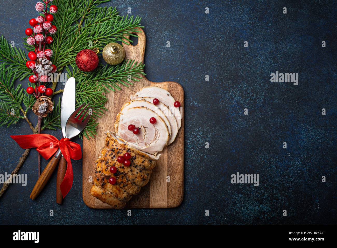 Jambon de Noël en tranches de baies rouges et décorations de fête Banque D'Images