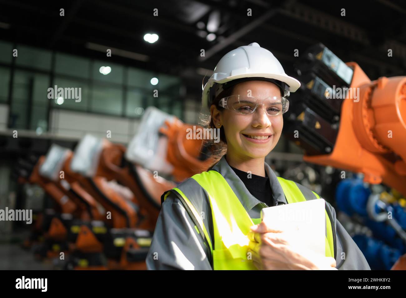 Portrait de femme ingénieur avec la mission d'auditer, tester, améliorer les logiciels et calibrer le bras robotique. Banque D'Images