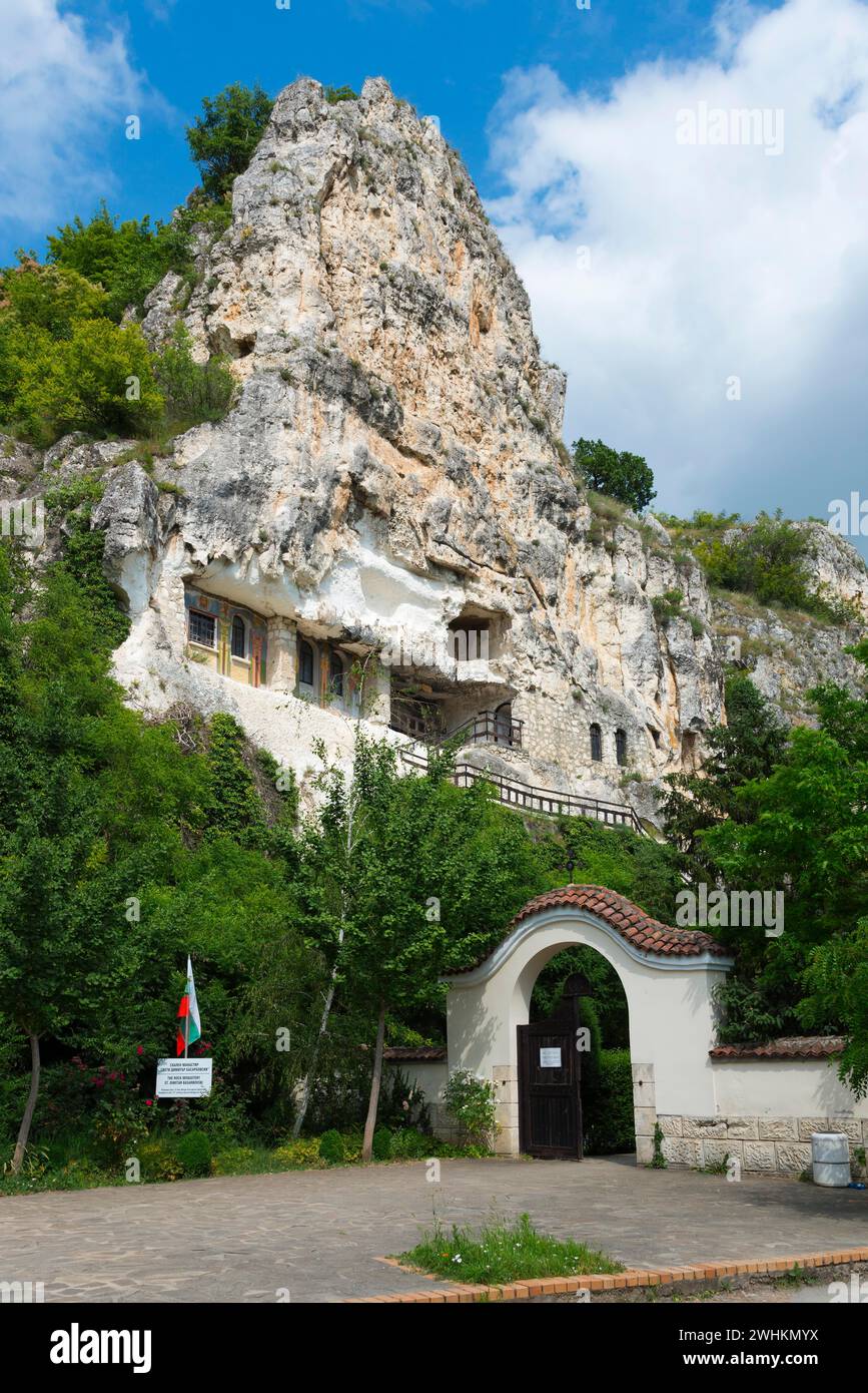 Complexe monastère dans un paysage rocheux avec porte verte et drapeau, monastère grotte orthodoxe bulgare, monastère rocheux, monastère Basarbowski Banque D'Images