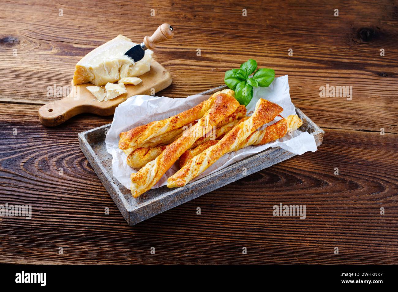 Bâtonnets de pâte feuilletée au parmesan italien traditionnel comme plat d'accompagnement grillé servi en gros plan dans un plateau en pierre design Banque D'Images