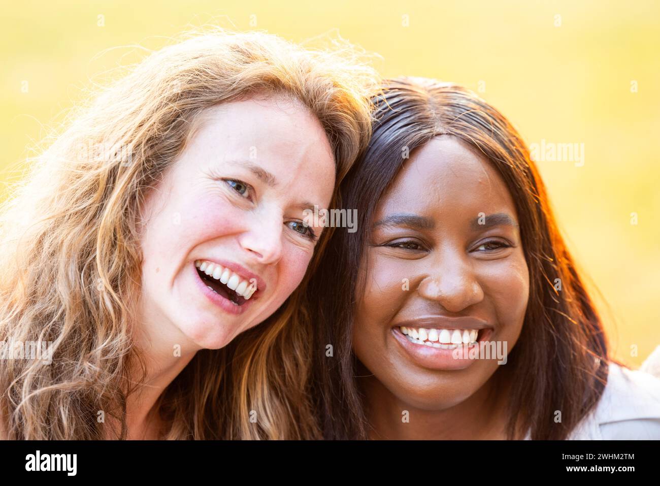 Sisterly Bond : Portrait souriant d'amies féminines multiethniques Banque D'Images