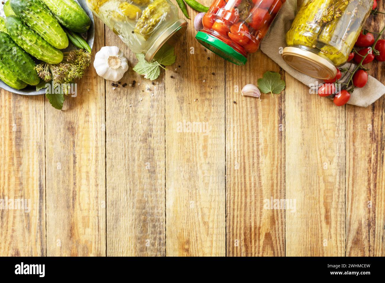 Concombres marinés salés et tomates conservés en conserve dans un bocal en verre. Économie domestique, préservation des récoltes d'automne. Homéma sain Banque D'Images