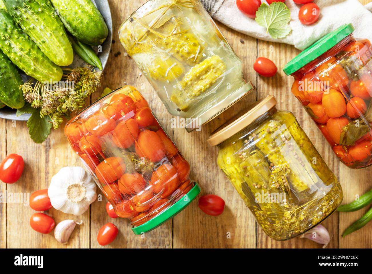 Concombres marinés salés et tomates conservés en conserve dans un bocal en verre. Économie domestique, préservation des récoltes d'automne. Homéma sain Banque D'Images