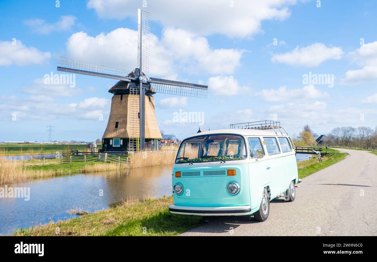 Road trip avec une vieille voiture vintage dans la région des bulbes floraux hollandais avec des champs de tulipes Banque D'Images