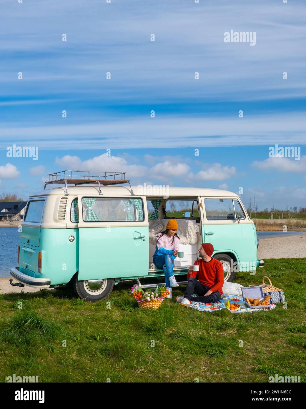 Couple faisant un Road trip avec une vieille voiture vintage dans la région des bulbes de fleurs hollandaises avec des champs de tulipes Banque D'Images