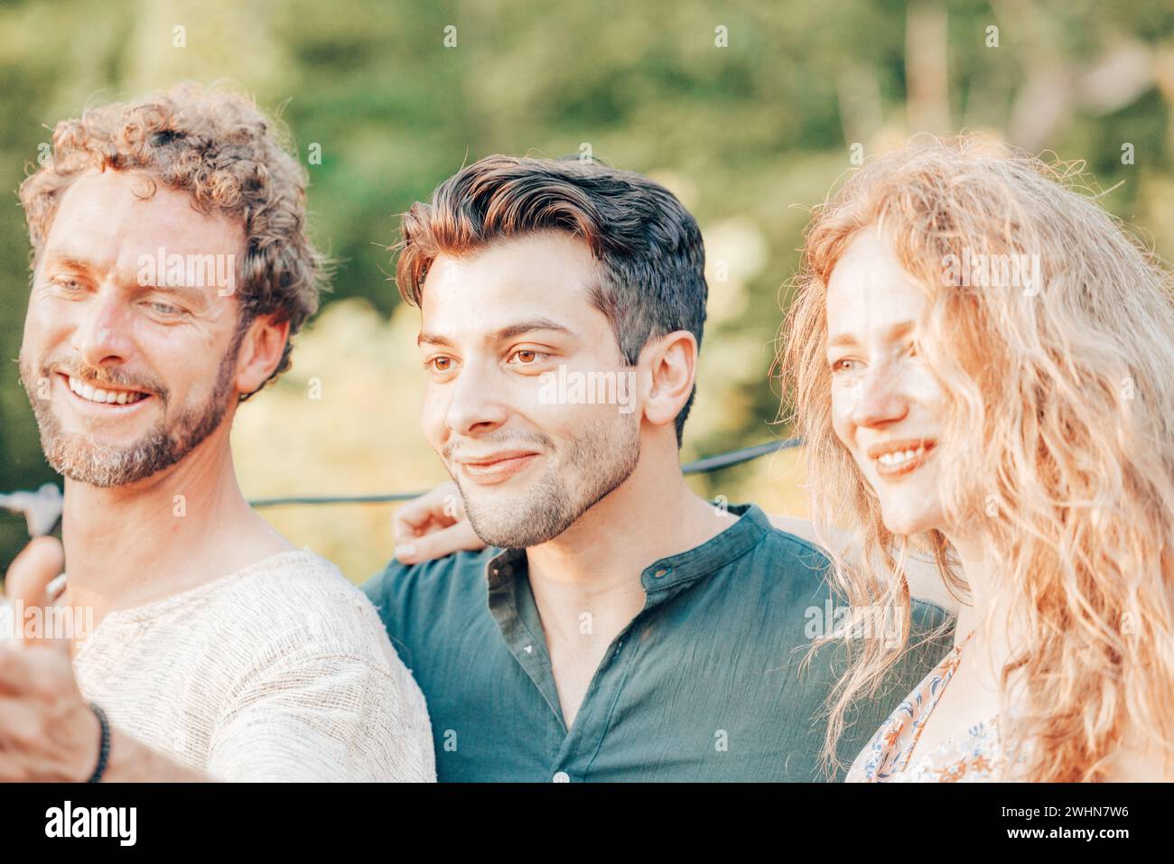 Petit groupe d'amis prenant une photo selfie souriant à la caméra, riant les jeunes célébrant debout dehors et ayant fu Banque D'Images