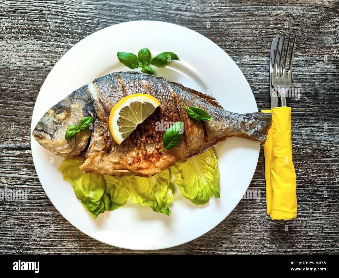 Poisson doré de la dorade sur l'assiette avec légumes, vue du dessus Banque D'Images