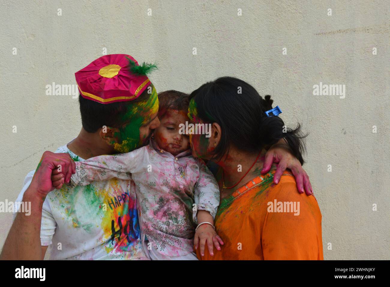 jeune couple jouant holi avec des enfants. Joyeux holi. Holi India. Banque D'Images