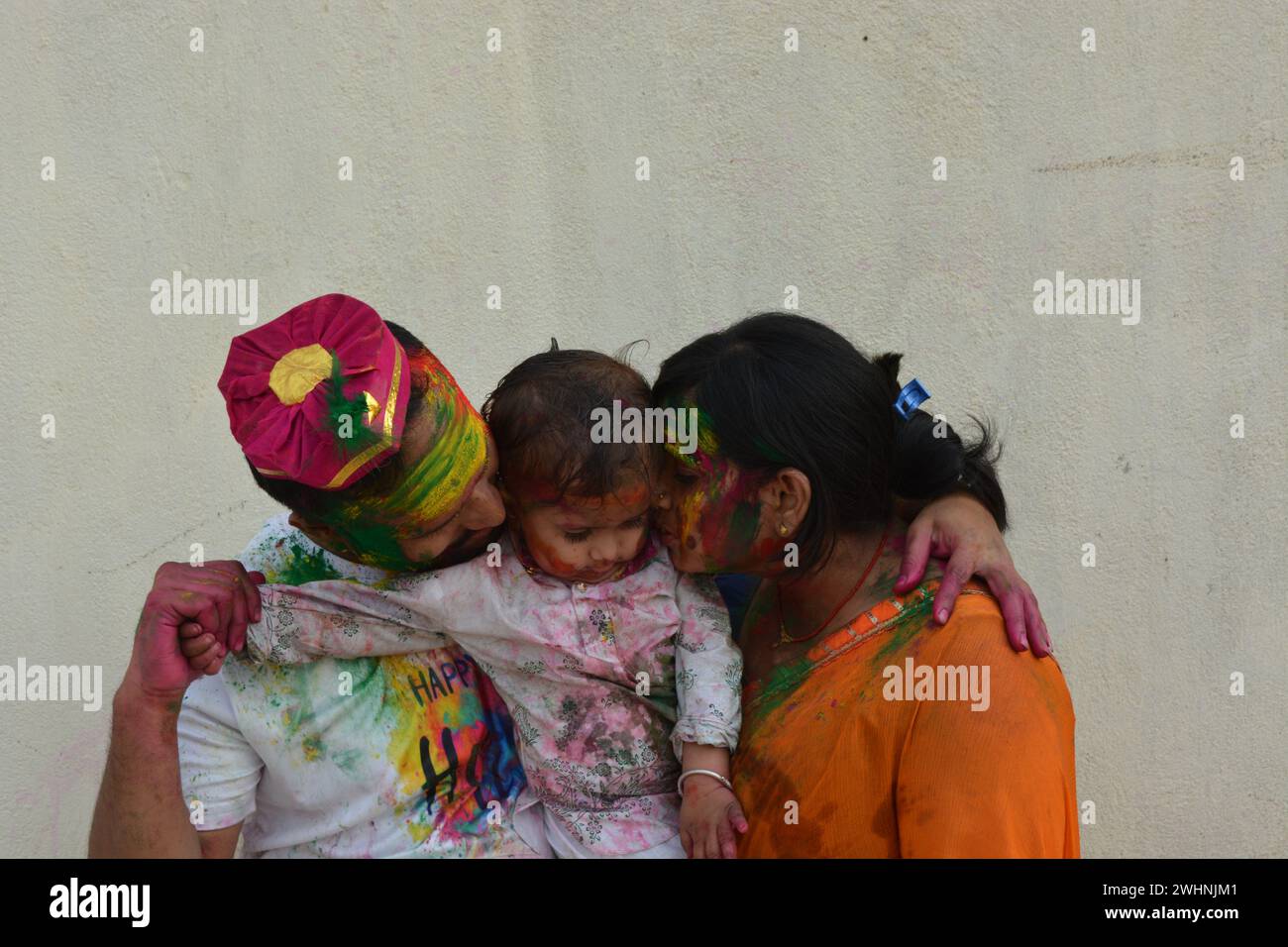 jeune couple jouant holi avec des enfants. Joyeux holi. Holi India. Banque D'Images