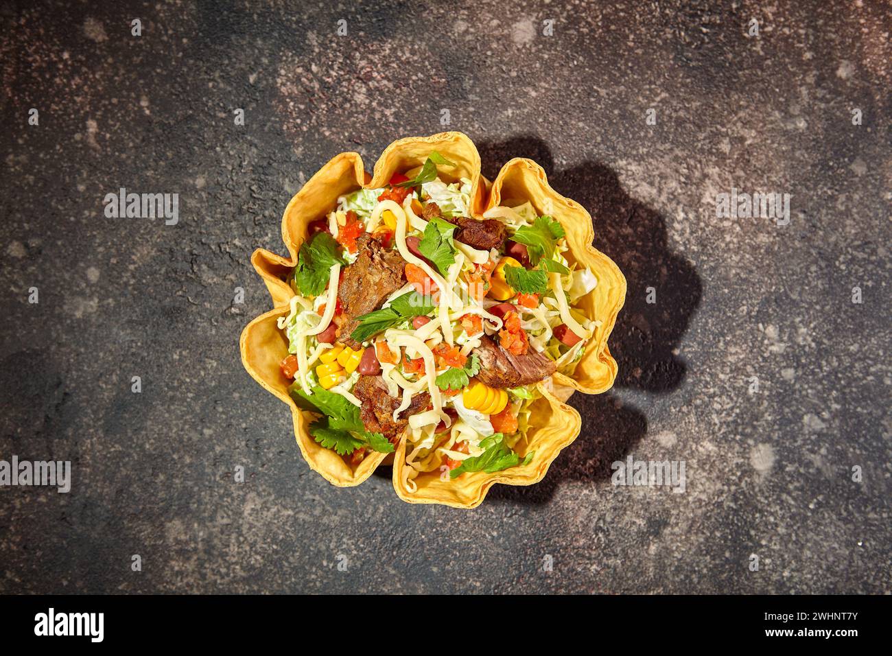 Salade de tacos dans un bol de tortilla avec du bœuf, du fromage, du maïs et de la laitue Banque D'Images