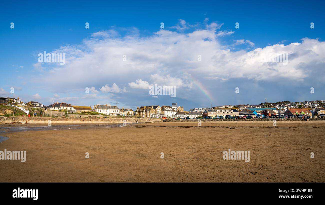 Perranporth, Cornouailles, Angleterre, Royaume-Uni - 05 juin 2022 : maisons près de la plage de Perranporth avec un arc-en-ciel en arrière-plan Banque D'Images