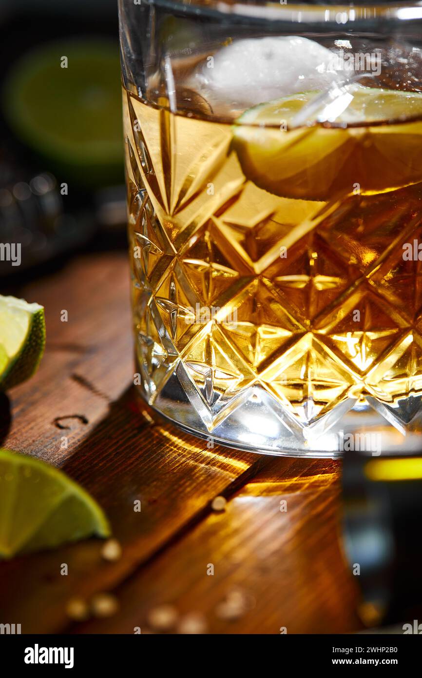 Boisson estivale, whisky, tequila ou cognac, limonade, cocktail alcoolisé ou non avec citrons verts et sel sur une table en bois Banque D'Images