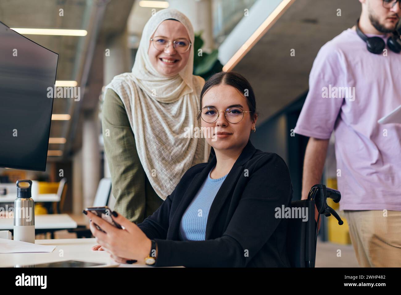 Dans une start-up moderne dynamique et diversifiée, un groupe de femmes d’affaires contemporaines, dont une portant un hijab, se réunissent, ex Banque D'Images