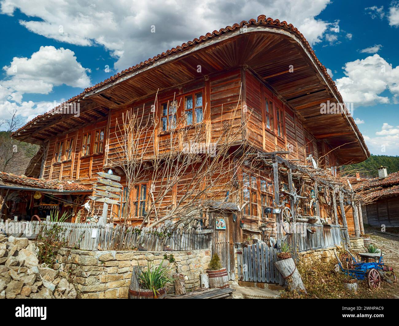 Zheravna, Bulgarie - route pavées étroites et rustique des maisons traditionnelles en pierre et bois avec bigroot géranium sanguin (Geranium macrorrhizum) le long e Banque D'Images