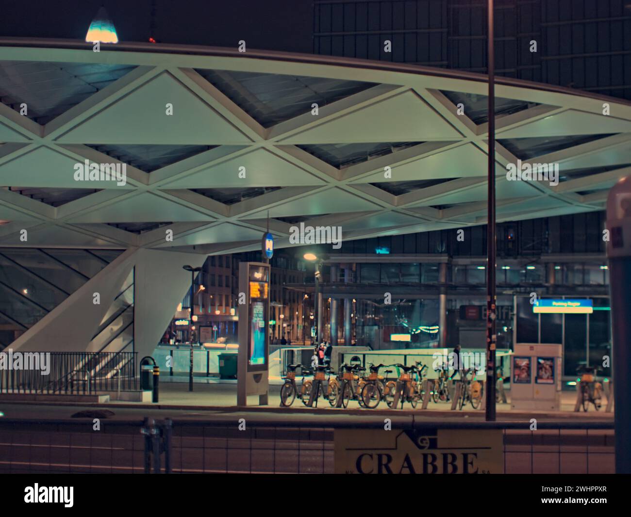 Bruxelles, Belgique. 5 février 2024. Photographie abstraite d'un paysage de rue. Façade du bâtiment Starbucks. Vélos de ville et station de métro Roger. Banque D'Images