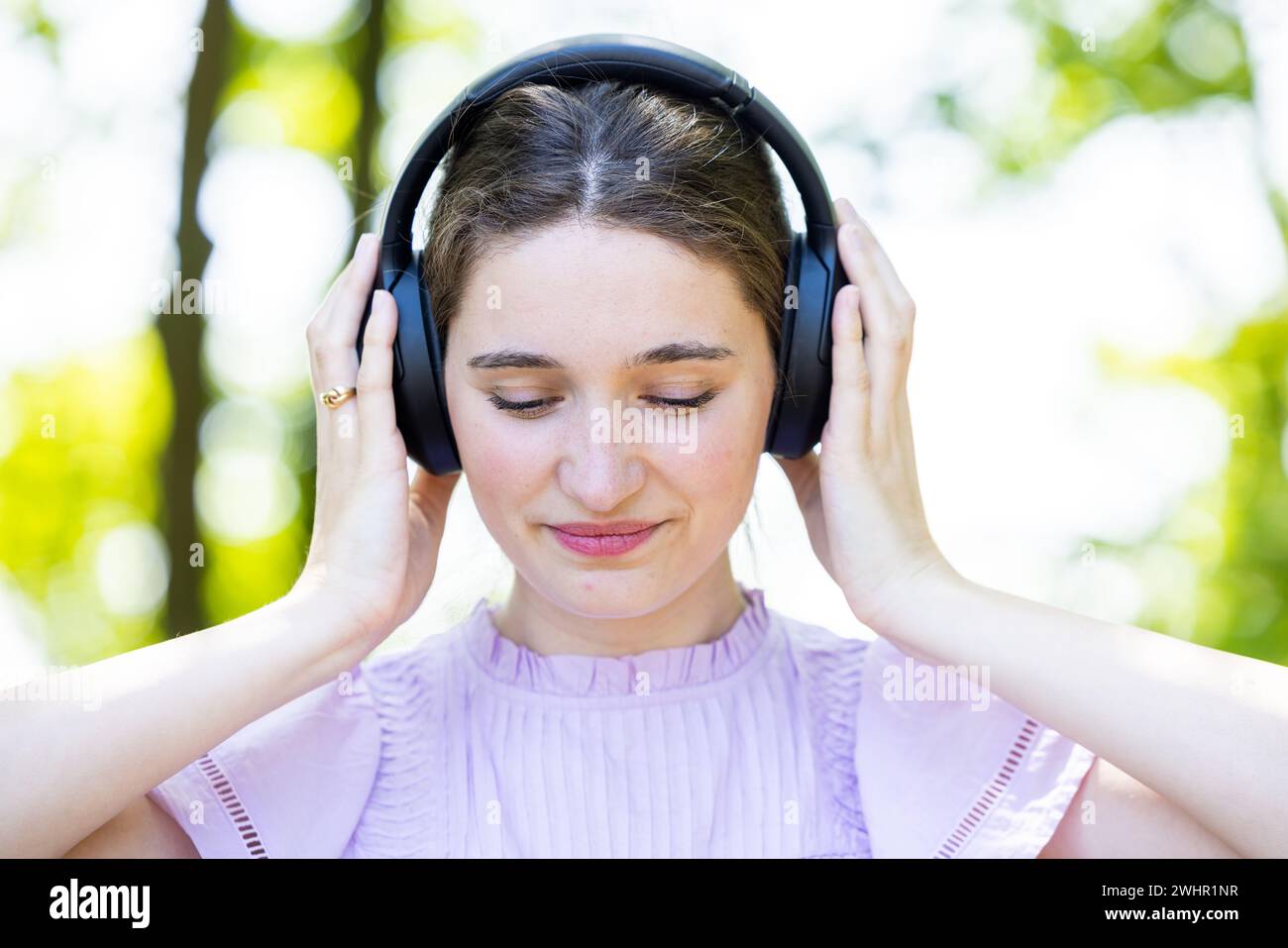 Connexion musicale intense : jeune femme dans la nature sereine Banque D'Images