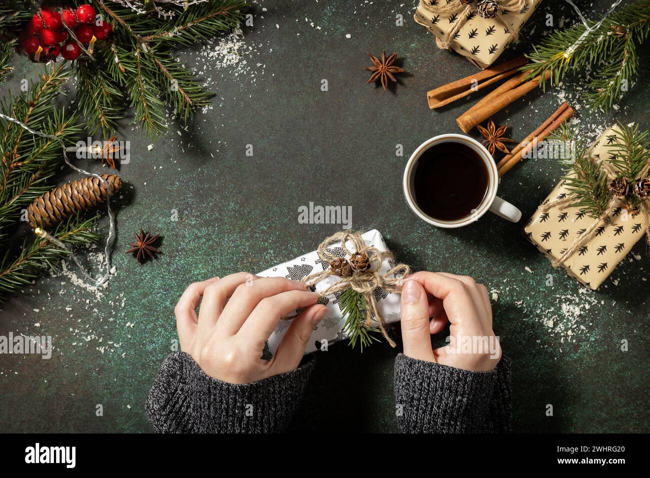 Concept hiver. Flatlay composition avec des mains féminines tiennent le cadeau de Noël et de café sur un fond de pierre sombre. Copier spac Banque D'Images